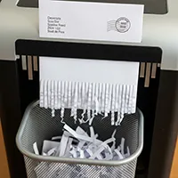 In this photo, a mailed order is being fed through a shredder, effectively canceling it.