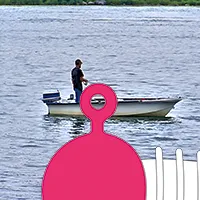 This image showcases a fisherman in his boat, viewed through the paint-free eyelet of a jig head.